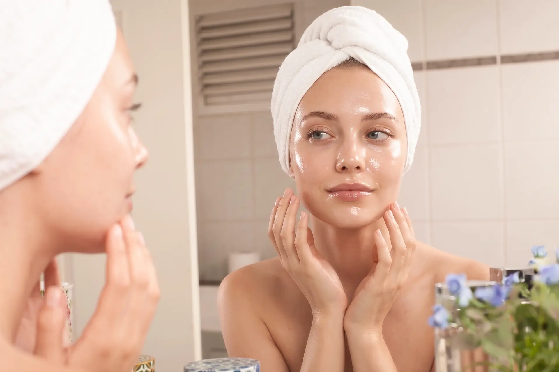 Woman with glowing hydrated skin looking in the mirror